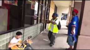A Man Playing Guitar Is Joined By Two Strangers In An Impromptu Street Performance.